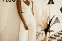 a bold and catchy bridal look with high waisted wideleg pants, a crop top with thick straps and a deep neckline, sneakers and oversized earrings