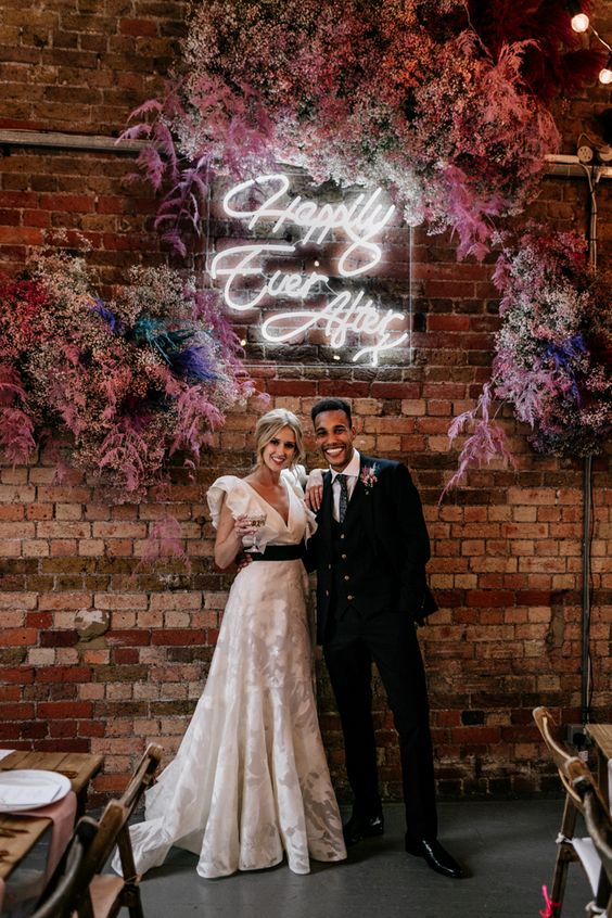 a bold wedding backdrop of colorful baby's breath and grasses, a neon sign is a lovely and cool solution to rock