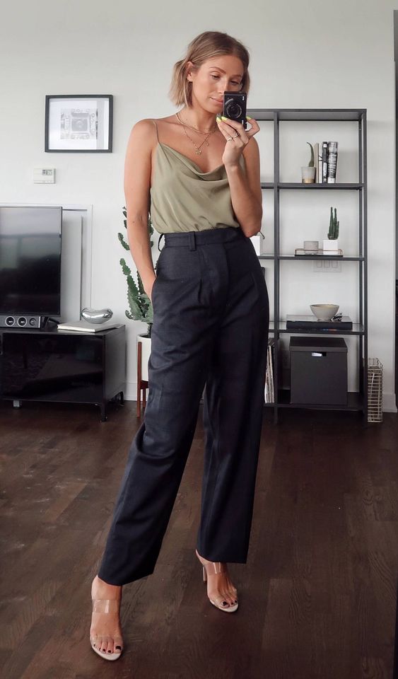 a bold wedding guest look with an olive green spaghetti strap top, black leather pants, clear heeled mules and layered necklaces