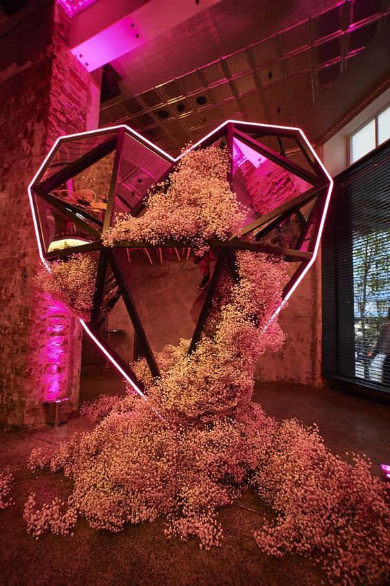 a breathtaking wedding backdrop of a large neon sign, pink mirror, pink baby's breath is an amazing idea