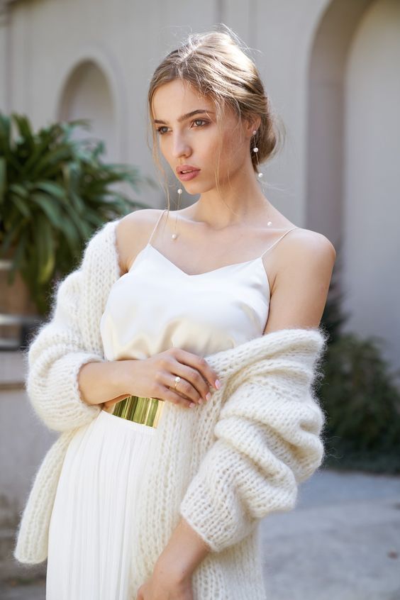 a casual winter bridal look with a spaghetti strap top, a pleated skirt, a chunky cardigan and a gold belt plus pearl earrings