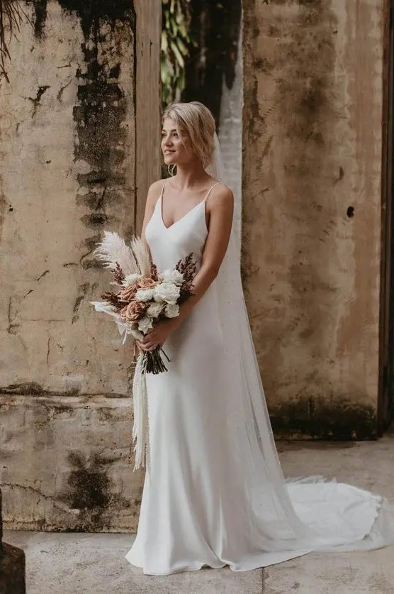 a classic slip wedding dress is a very minimal option, and it's always in trend, accessorize it with a cool veil