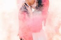 a couple kissing in colorful smoke is a great and veyr emotional wedding portrait idea