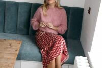a cozy wedding guest outfit with a pink chunky knit sweater, a red printed sequin skirt, black shoes and pearl earrings