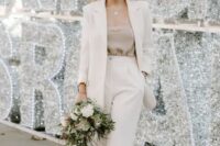 a creamy pantsuit with cropped trousers and an oversized blazer, blue embellished shoes and a headband for a glam winter wedding