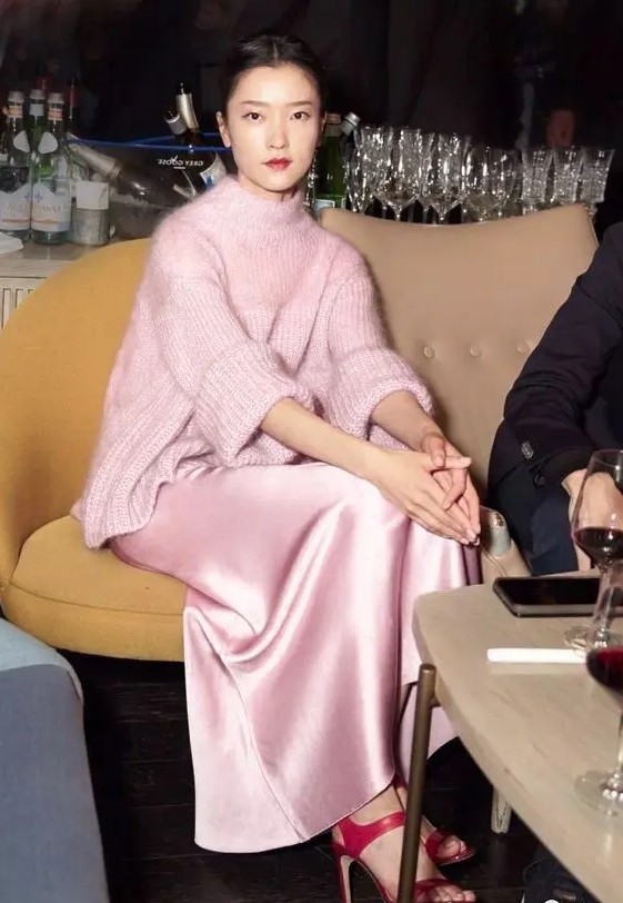 a feminine and tender outfit idea with a pink silk dress, an oversized turtleneck sweater and fuchsia high heels