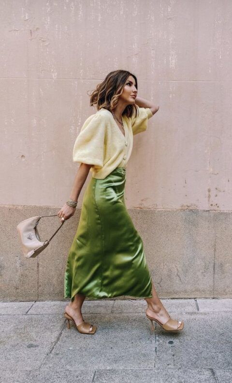 a lovely fall wedding guest look with a neutral cardigan tucked into a green stain midi, tan mules and a tan bag