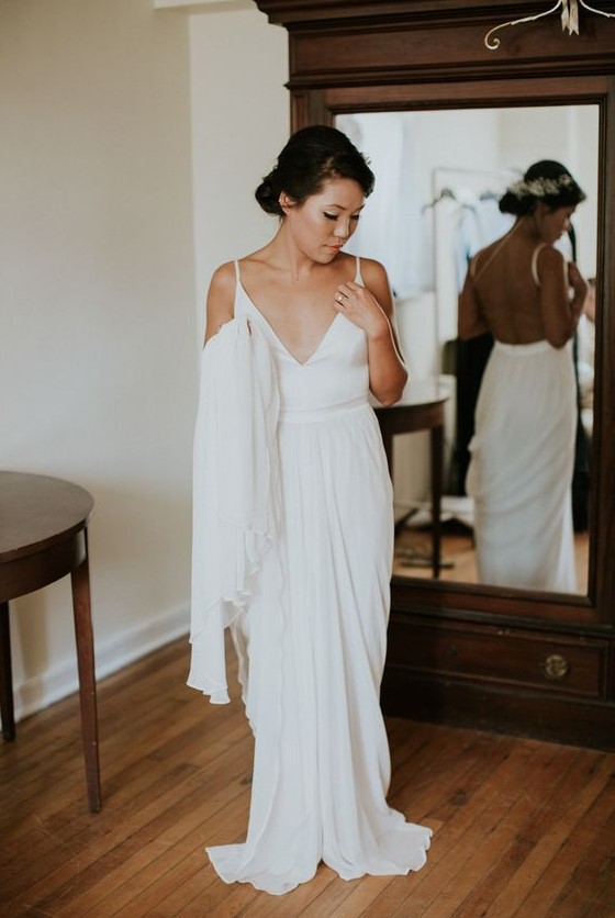 a minimalist sheath wedding dress with a sleek plain bodice and a draped skirt with a small train plus spaghetti straps