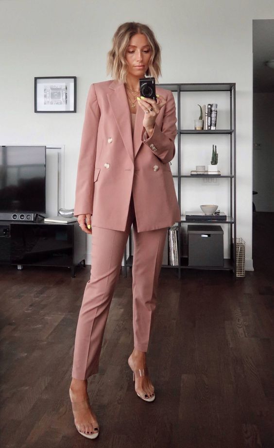 a pink pantsuit, a blush top, clear mules and layered necklaces are a gorgeous and stylish outfit for a wedding