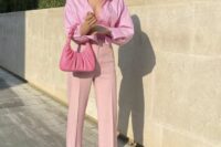 a pink wedding guest outfit with a top, an oversized shirt, high waisted pants with slits, pink shoes adn a small bag