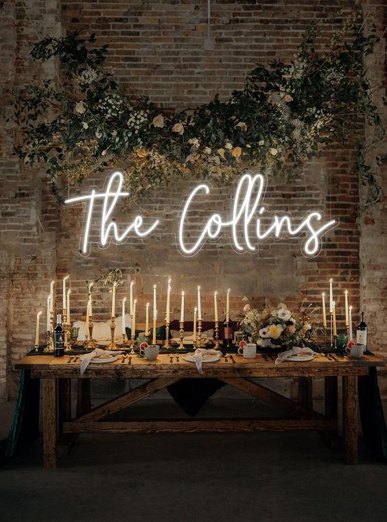 a small wedding reception space with a neon sign and an overhead floral installation is amazing