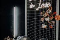 a stylish wedding backdrop of mesh, a neon sign, white, pink and rust blooms and disco balls is wow