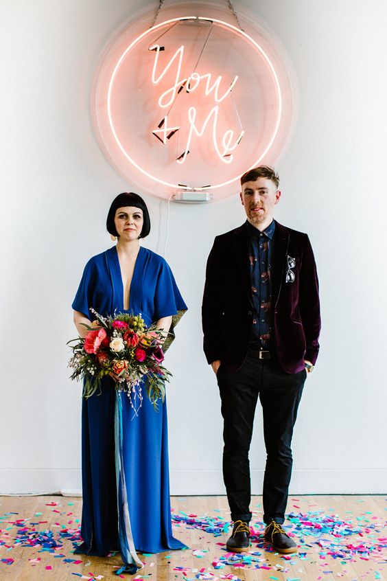 a unique wedding backdrop of a wedding neon sign and some confetti is a lovely solution done in bold colors