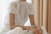 a white jumpsuit with a sheer pleated bodice and short sleeves and plain pants for a modern bride