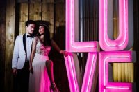 an oversized neon sign is a gorgeous decor idea for a wedding venue or even for a modern wedding ceremony