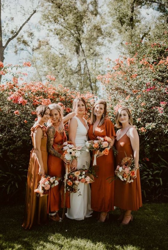 beautiful mismatching bridesmaid dresses - a yellow, orange ones and a rust one, midi and maxi for a trendy modern wedding