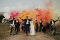 everyone rocking colorful smoke bombs as a creative idea for a wedding exit
