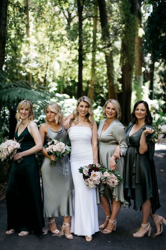 mismatching dark green and grey midi bridesmaid dresses with and without sleeves and matching shoes for a green wedding