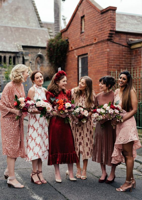 mismatching midi bridesmaid dresses in pink and burgundy, with various prints look awesome