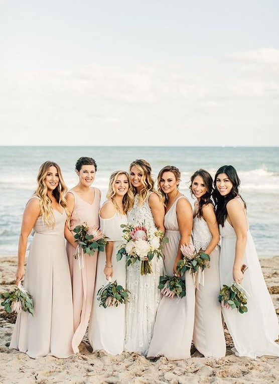 mismatching neutral beach bridesmaid dresses in cream and blush, with various designs and necklines