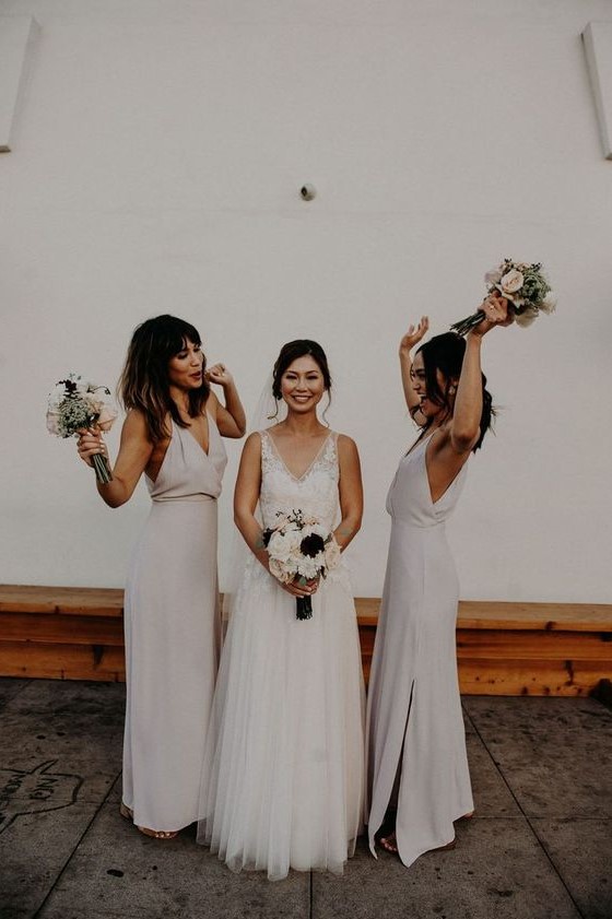 Neutral minimalist maxi bridesmaid dresses with deep V necklines and side slits are trendy