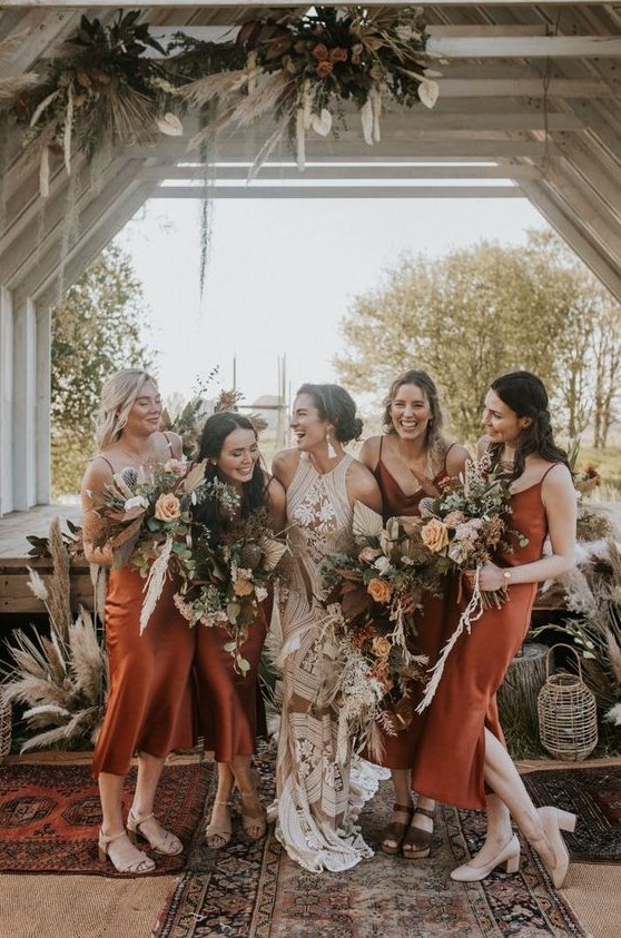 Rust colored midi silk slip bridesmaid dresses are a trendy idea thanks to their earthy tone