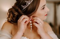 03 The bride was wearing an off the shoulder wedding dress with an embellished bodice, a crystal crown and statement pearl earrings
