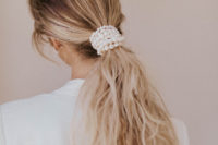 05 a low and messy ponytail wrapped up in pearls is a chic idea for a modern or minimalist bride