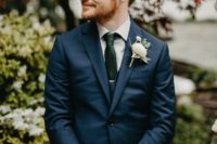 06 a navy three-piece suit, a dark green tie and a neutral floral boutonniere to refresh the whole look