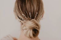 07 a low bun accented with a large hair barrette with pearls looks modern, feminine and very chic