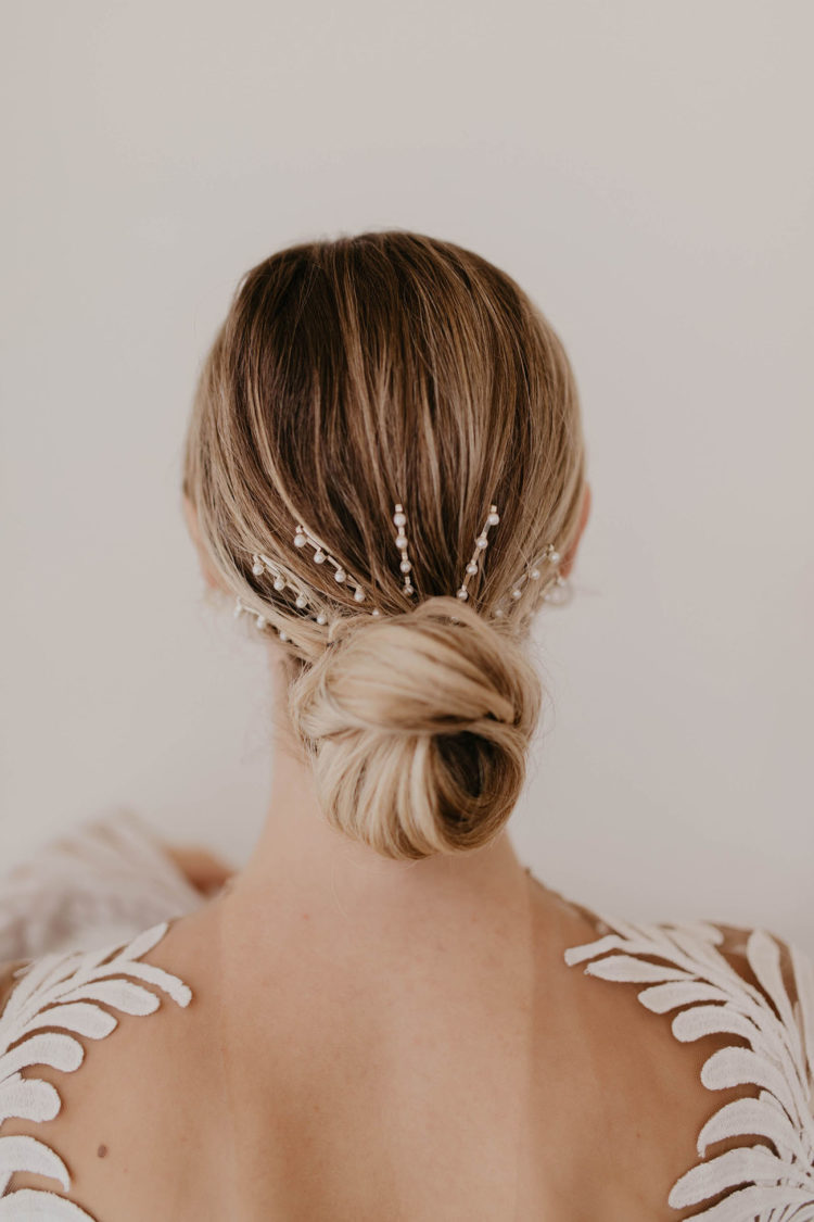 a low bun accented with a large hair barrette with pearls looks modern, feminine and very chic