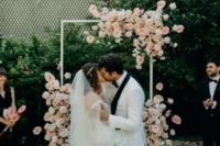08 The wedding arch was decorated with super lush blush blooms for a romantic feel