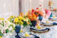 09 The wedding reception space was done with bright ombre blooms, navy touches and printed plates and tablecloths plus tall candles