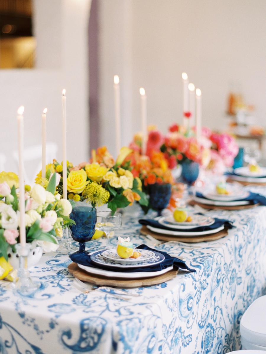 The wedding reception space was done with bright ombre blooms, navy touches and printed plates and tablecloths plus tall candles