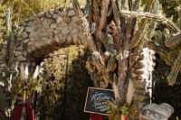 03 The entrance was decorated in a witchy way, with pampas grass, greenery and moody blooms, burgundy fabric and signs