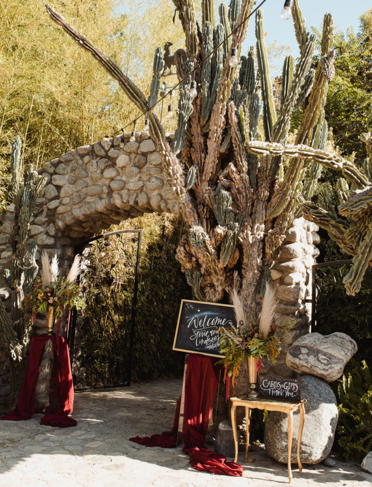 The entrance was decorated in a witchy way, with pampas grass, greenery and moody blooms, burgundy fabric and signs