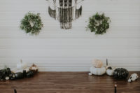 03 The wedding ceremony space was done with moody and white blooms, greenery, black macrame, greenery wreaths and pumpkins