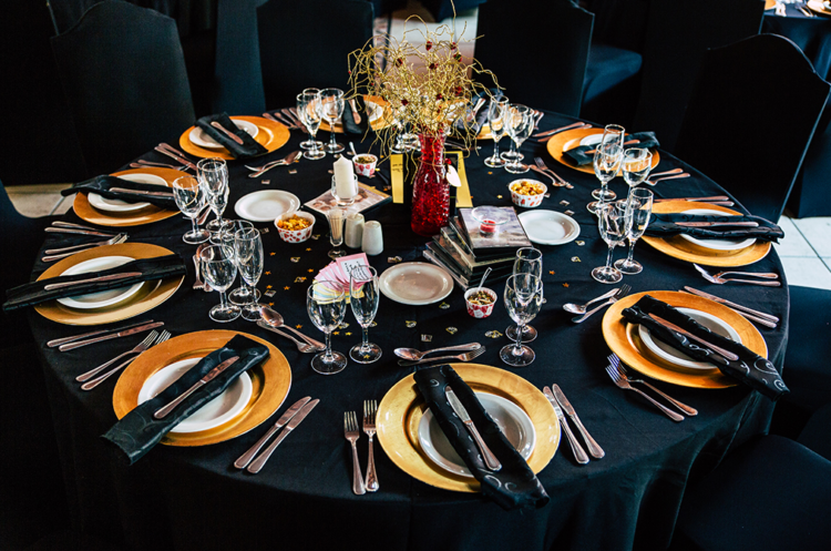 The wedding tables were styled in black and marigold, with a quirky centerpiece in a red vase and rhinestones and stars