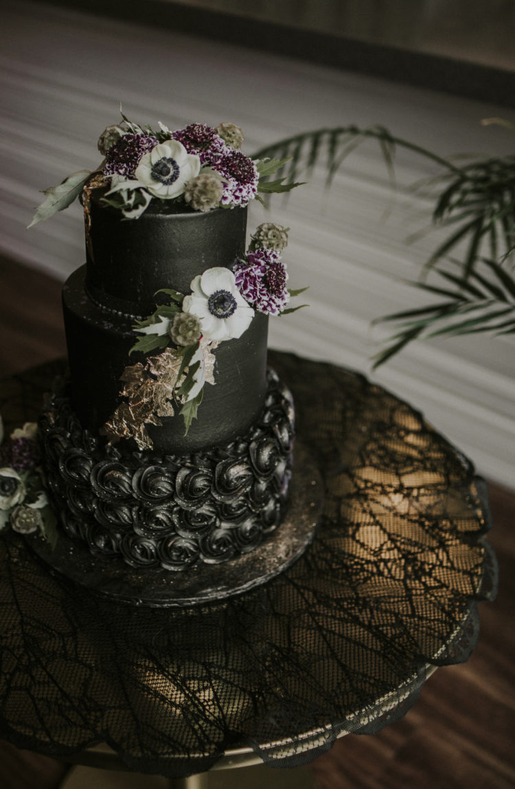The wedding cake was a black one, with gold leaf and fresh blooms and greenery