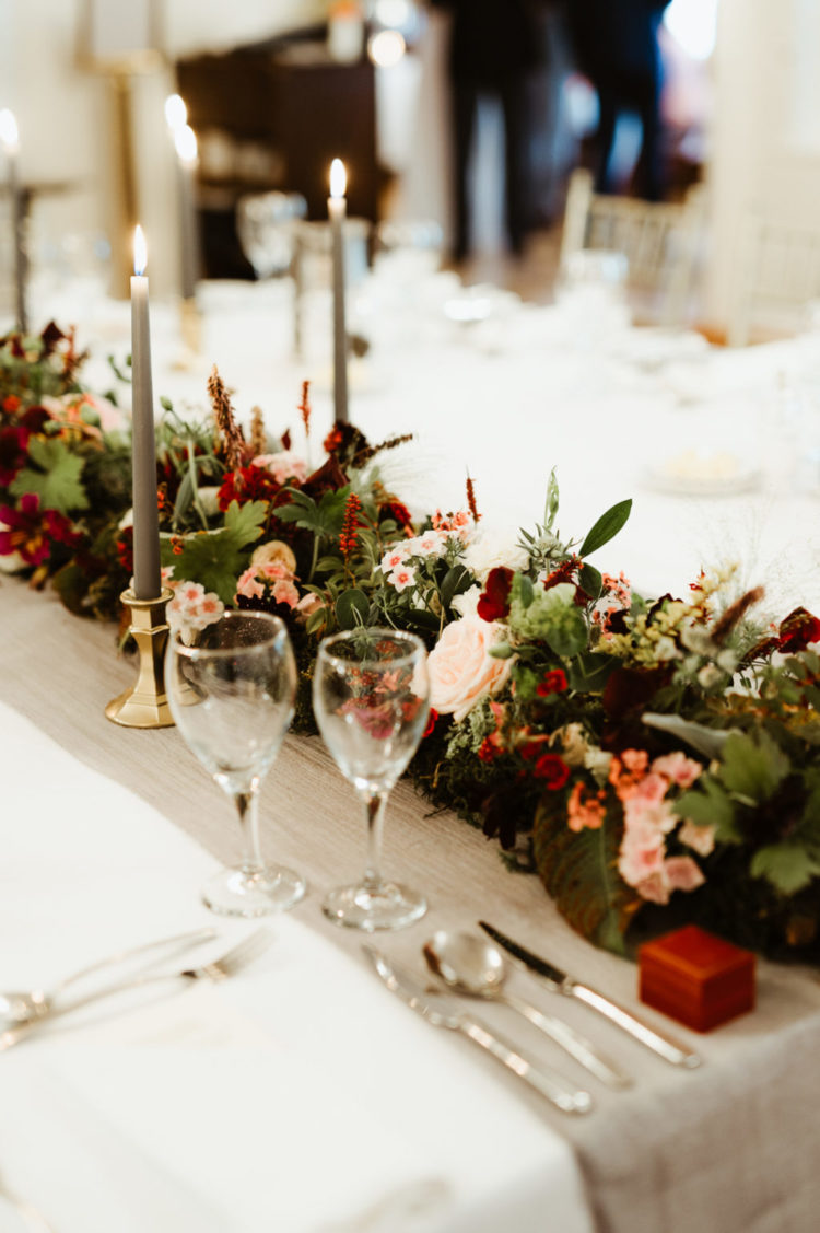 The wedding tablescape was done with bright and blush blooms and greenery, with grey candles and neutral tablecloths