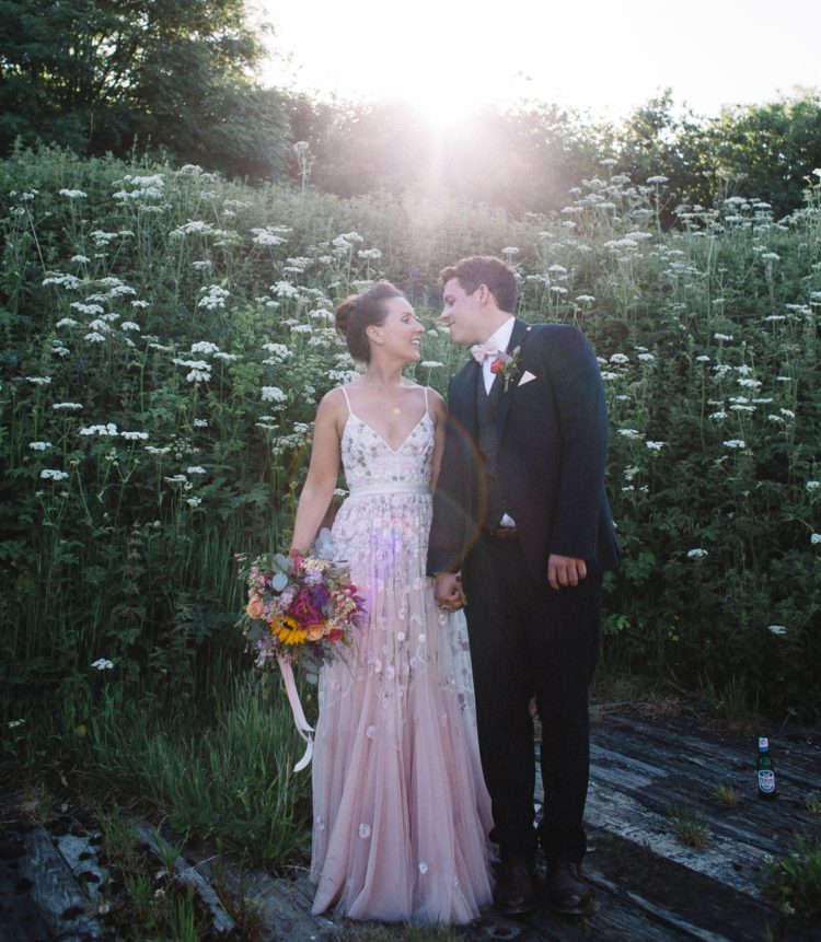 a pink spaghetti strap wedding dress with floral appliques and embroidery plus a highlighted waistline