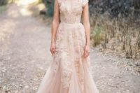 13 a sleeveless blush pink wedding dress with lace appliques that add a trendy touch and a deep V-neckline