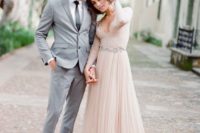 15 a blush A-line wedding dress with a lace bodice, a plunging neckline, long sleeves and a layered skirt plus a train