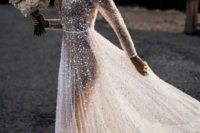 17 a fully embellished A-line see-through wedding dress with a covered plunging neckline and long sleeves