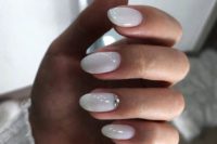 18 shiny white nails with a large rhinestone on the ring finger is a chic idea for a bride who loves glam