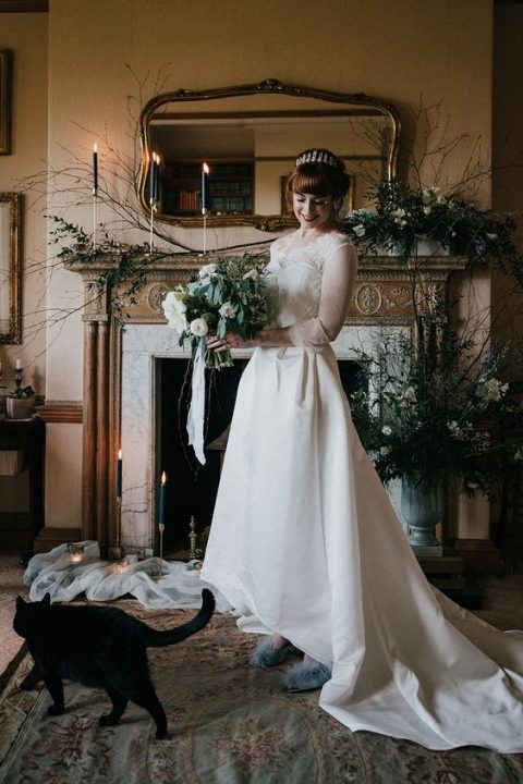 a romantic A-line wedding dress with a lace bodice, illusion sleeves and a neckline plus a high low skirt with a train