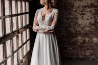22 a wedding gown with a lace bodice with an illusion plunging neckline, long sleeves and a flowy skirt with a train