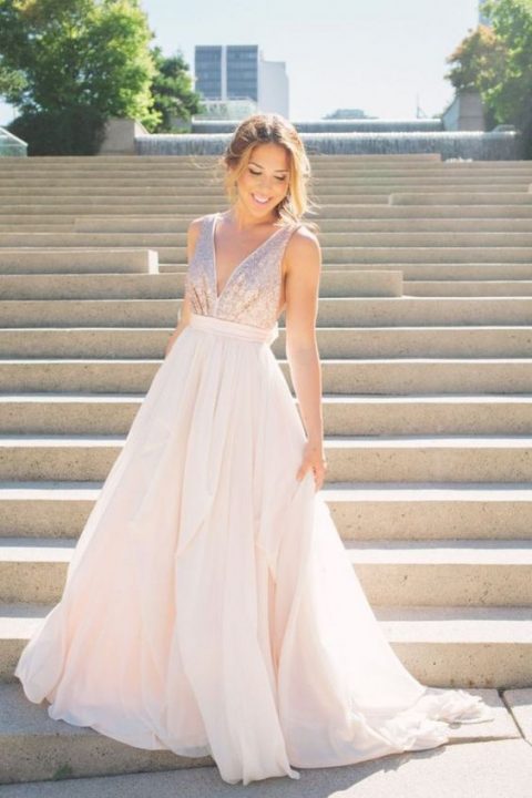 a sleeveless light pink wedding gown with a sequin bodice and a plain full skirt, a plunging neckline