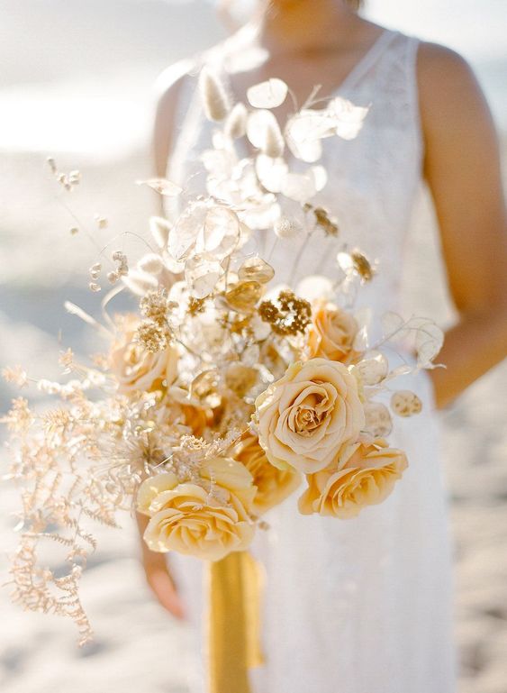 a golden wedding bouquet with marigold and blush blooms, lunaria and some dried herbs for a fall bride