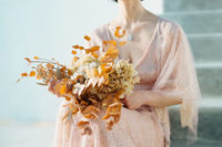 a rust-colored wedding buquet with dried eucalyptus and hydrangeas is a great idea for fall